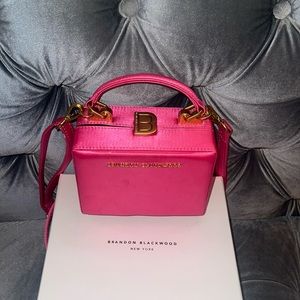 Mini Kendrick Trunk -Hot pink satin Used.  spot on left side of purse.
